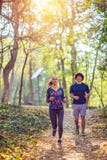 Cardio тренировка - пара наслаждаясь в здоровом образе жизни пока jogging вдоль леса стоковая фотография Cardio тренировка - пара наслаждаясь в здоровом образе жизни пока jogging вдоль леса стоковая фотография