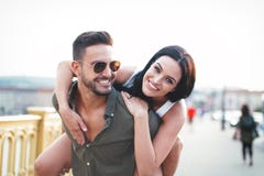 Carefree young caucasian couple in city doing piggyback at outdoors stock photos Carefree young caucasian couple in city doing piggyback at outdoors stock photos