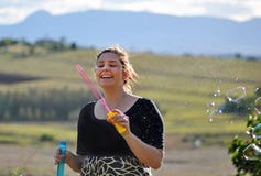 Carefree young woman blowing bubbles in country royalty free stock image Carefree young woman blowing bubbles in country royalty free stock image