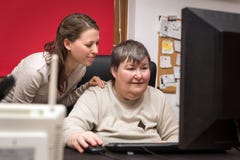 Caregiver and mentally disabled woman learning at the computer