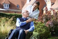 Carer Pushing Senior Man In Wheelchair stock image Carer Pushing Senior Man In Wheelchair stock image