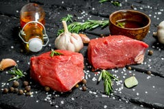 Carne sin procesar Pedazos cortados de carne de vaca con las especias y las hierbas en un tablero de madera imágenes de archivo libres de regalías Carne sin procesar Pedazos cortados de carne de vaca con las especias y las hierbas en un tablero de madera imágenes de archivo libres de regalías