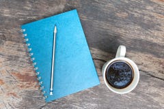 Carnet bleu avec la cuvette de café Photographie stock Carnet bleu avec la cuvette de café Photographie stock