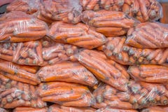 Carottes à un arrière-plan de sachets en plastique images libres de droits Carottes à un arrière-plan de sachets en plastique images libres de droits