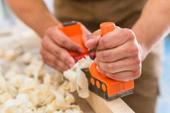 Carpenter with wood planer working on piece stock photo Carpenter with wood planer working on piece stock photo