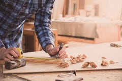 Carpenter working with meter or rule taking measures on wood using pencil. Workshop background stock image Carpenter working with meter or rule taking measures on wood using pencil. Workshop background stock image