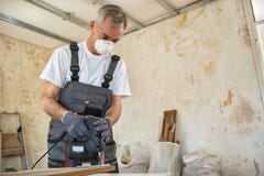 Carpenter working with wood plank at workshop stock photo Carpenter working with wood plank at workshop stock photo