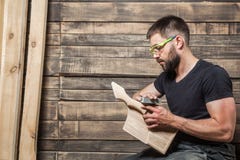 Carpentiere con una barba che si siede su un rivestimento del banco immagini stock libere da diritti Carpentiere con una barba che si siede su un rivestimento del banco immagini stock libere da diritti
