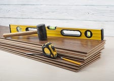 Carpentry concept.Different tools- level,tape-measure,rubber hammer on the new laminate flooring.Copy space for text. stock image Carpentry concept.Different tools- level,tape-measure,rubber hammer on the new laminate flooring.Copy space for text. stock image