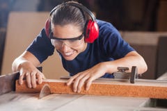 Carpintero de sexo femenino Cutting Wood With Tablesaw foto de archivo Carpintero de sexo femenino Cutting Wood With Tablesaw foto de archivo
