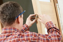 Carpintero de sexo masculino en la instalación de la cerradura foto de archivo Carpintero de sexo masculino en la instalación de la cerradura foto de archivo