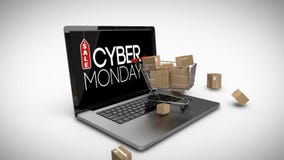 Carrello con le scatole sul computer portatile che visualizza il segno cyber di vendita di lunedì Carrello con le scatole sul computer portatile che visualizza il segno cyber di vendita di lunedì