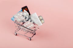 Carrinho de compras carregado com os comprimidos em um fundo cor-de-rosa O conceito da medicina e a venda das drogas Copie o espa imagens de stock royalty free Carrinho de compras carregado com os comprimidos em um fundo cor-de-rosa O conceito da medicina e a venda das drogas Copie o espa imagens de stock royalty free