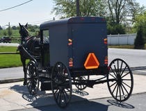 Carrinho puxado a cavalo de Amish estacionado em uma loja fotografia de stock Carrinho puxado a cavalo de Amish estacionado em uma loja fotografia de stock