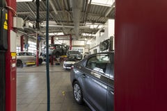 Carros luxuosos que estão sendo reparados em uma garagem moderna Vista com o vermelho fotos de stock Carros luxuosos que estão sendo reparados em uma garagem moderna Vista com o vermelho fotos de stock