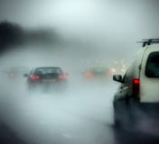 Cars on a road in heavy rain and fog