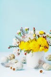 Carte de voeux de Pâques avec les fleurs, la plume et les oeufs de caille colorés sur le fond bleu Belle composition en ressort photo stock Carte de voeux de Pâques avec les fleurs, la plume et les oeufs de caille colorés sur le fond bleu Belle composition en ressort photo stock