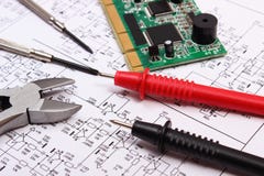 Carte électronique, outils de précision et câble de multimètre sur le diagramme de l'électronique Image stock