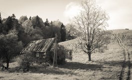 Casa abandonada vieja de la granja debajo de la colina imagen de archivo Casa abandonada vieja de la granja debajo de la colina imagen de archivo