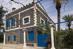 Casa di pietra nera con le finestre blu immagine stock Casa di pietra nera con le finestre blu immagine stock