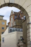 Casa do multi-n?vel do tijolo com as grandes janelas bonitas Imagem tomada atrav?s do arco velho Skyline de Londres foto de stock Casa do multi-n?vel do tijolo com as grandes janelas bonitas Imagem tomada atrav?s do arco velho Skyline de Londres foto de stock