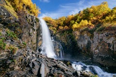 Cascata nelle montagne nella caduta immagine stock libera da diritti Cascata nelle montagne nella caduta immagine stock libera da diritti