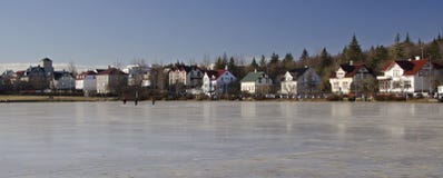 Case islanian variopinte tradizionali sulle rive di un lago congelato a Reykjavik fotografia stock libera da diritti Case islanian variopinte tradizionali sulle rive di un lago congelato a Reykjavik fotografia stock libera da diritti