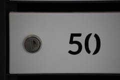 Casella di numero per posta, raccolta separata dei pacchetti e delle lettere e giornali in una costruzione multipiana scatola con immagine stock Casella di numero per posta, raccolta separata dei pacchetti e delle lettere e giornali in una costruzione multipiana scatola con immagine stock