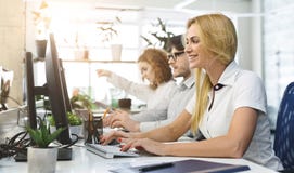 Casual business team working on computers in office stock image Casual business team working on computers in office stock image
