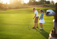 Casual Kids At A Golf Field Holding Golf Clubs Stock Image