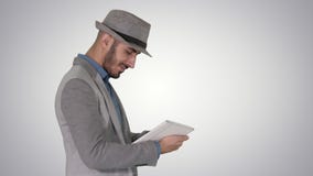 Casual man using tablet and smiling while waking on gradient background. stock video footage Casual man using tablet and smiling while waking on gradient background. stock video footage