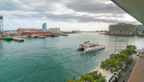 Catamaran iść pobliskim Portowym Vell marina w Catalonia Barcelona na zatoce, ludzie chodzi wzdłuż niższego pozioma Obrazy Royalty Free