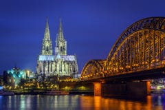 Catedral da ponte de Hohenzollern da água de Colônia na hora azul imagens de stock Catedral da ponte de Hohenzollern da água de Colônia na hora azul imagens de stock