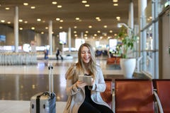 Caucasain young woman using internet by tablet in airport hall near valise. stock images Caucasain young woman using internet by tablet in airport hall near valise. stock images
