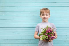 Caucasian boy the teenager against the background of a blue wall from old boards with a bouquet of seedling of c royalty free stock photos Caucasian boy the teenager against the background of a blue wall from old boards with a bouquet of seedling of c royalty free stock photos