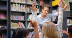 Caucasian female teacher teaching schoolkids in the school library 4k stock video Caucasian female teacher teaching schoolkids in the school library 4k stock video