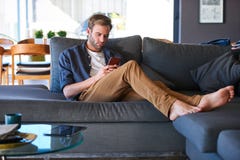 Caucasian man busy texting while sitting in a modern home Royalty Free Stock Photo Caucasian man busy texting while sitting in a modern home Royalty Free Stock Photo