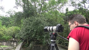 Caucasian Photographer takes pictures with DSLR camera stock footage Caucasian Photographer takes pictures with DSLR camera stock footage