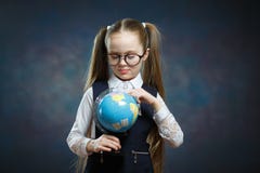 Caucasian skolflickakläderexponeringsglas vänder världsjordklotet royaltyfri bild Caucasian skolflickakläderexponeringsglas vänder världsjordklotet royaltyfri bild