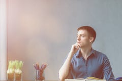 Caucasians novos do homem de negócios que sentam-se na tabela do escritório da mesa e que tomam notas no caderno Olhando para for fotos de stock Caucasians novos do homem de negócios que sentam-se na tabela do escritório da mesa e que tomam notas no caderno Olhando para for fotos de stock