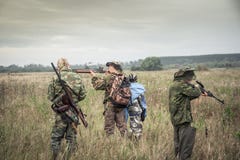 Cazadores que se preparan para cazar en campo rural en día cubierto durante temporada de caza Fotografía de archivo Cazadores que se preparan para cazar en campo rural en día cubierto durante temporada de caza Fotografía de archivo
