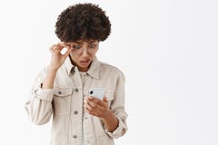 Ce qui Le portrait de l'Afro-américain intense confus et interrogé ne peut pas croire à l'absurdité qu'elle a lue par l'intermédi image stock Ce qui Le portrait de l'Afro-américain intense confus et interrogé ne peut pas croire à l'absurdité qu'elle a lue par l'intermédi image stock