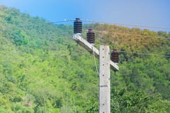 Ceramic insulation for electric cable hanging on the electric pylon with blue sky and green natural background. royalty free stock photo Ceramic insulation for electric cable hanging on the electric pylon with blue sky and green natural background. royalty free stock photo