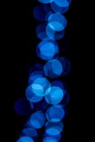 Cerchi blu del bokeh su un fondo nero immagine stock Cerchi blu del bokeh su un fondo nero immagine stock
