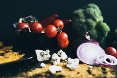 Cereza fresca deliciosa de los tomates y pimientas de chile candentes en un plato negro que miente en una tabla de cortar de made foto de archivo libre de regalías Cereza fresca deliciosa de los tomates y pimientas de chile candentes en un plato negro que miente en una tabla de cortar de made foto de archivo libre de regalías