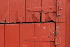 Cerniere di porta sulla vecchia porta di legno rossa rustica immagini stock Cerniere di porta sulla vecchia porta di legno rossa rustica immagini stock