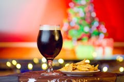 Cerveza oscura fría en fondo de la Navidad foto de archivo Cerveza oscura fría en fondo de la Navidad foto de archivo