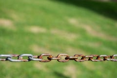 Chain with rust on green meadow background. Selective focus royalty free stock photos Chain with rust on green meadow background. Selective focus royalty free stock photos