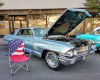 Chaise de jardin de drapeau américain près d'une voiture classique à un Car Show photo libre de droits Chaise de jardin de drapeau américain près d'une voiture classique à un Car Show photo libre de droits