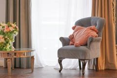 Chaise grise avec les oreillers et les fleurs roses dans la chambre photo libre de droits Chaise grise avec les oreillers et les fleurs roses dans la chambre photo libre de droits
